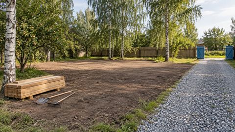 Расчищенный участок с сохранёнными деревьями, зоной хранения и свободным гравийным подъездом